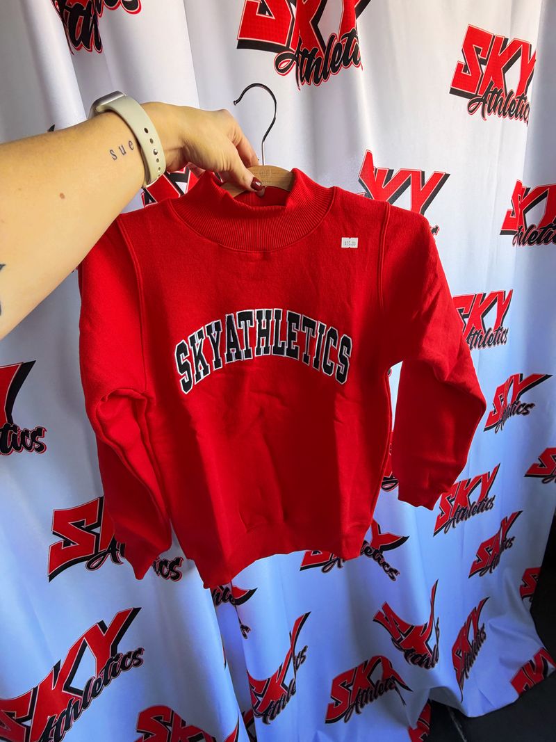 Red Sky crewneck held up in front of the Sky backdrop